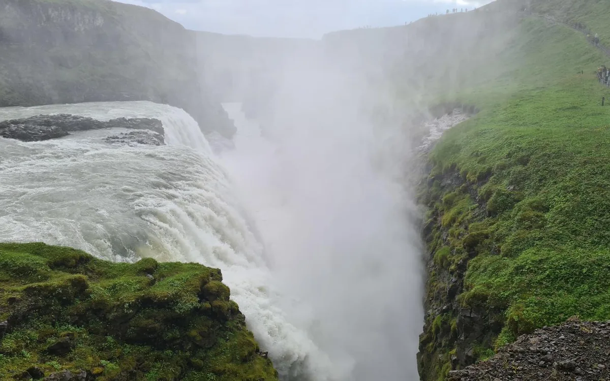 The upper tier of Gullfoss with green moss on the canyon walls