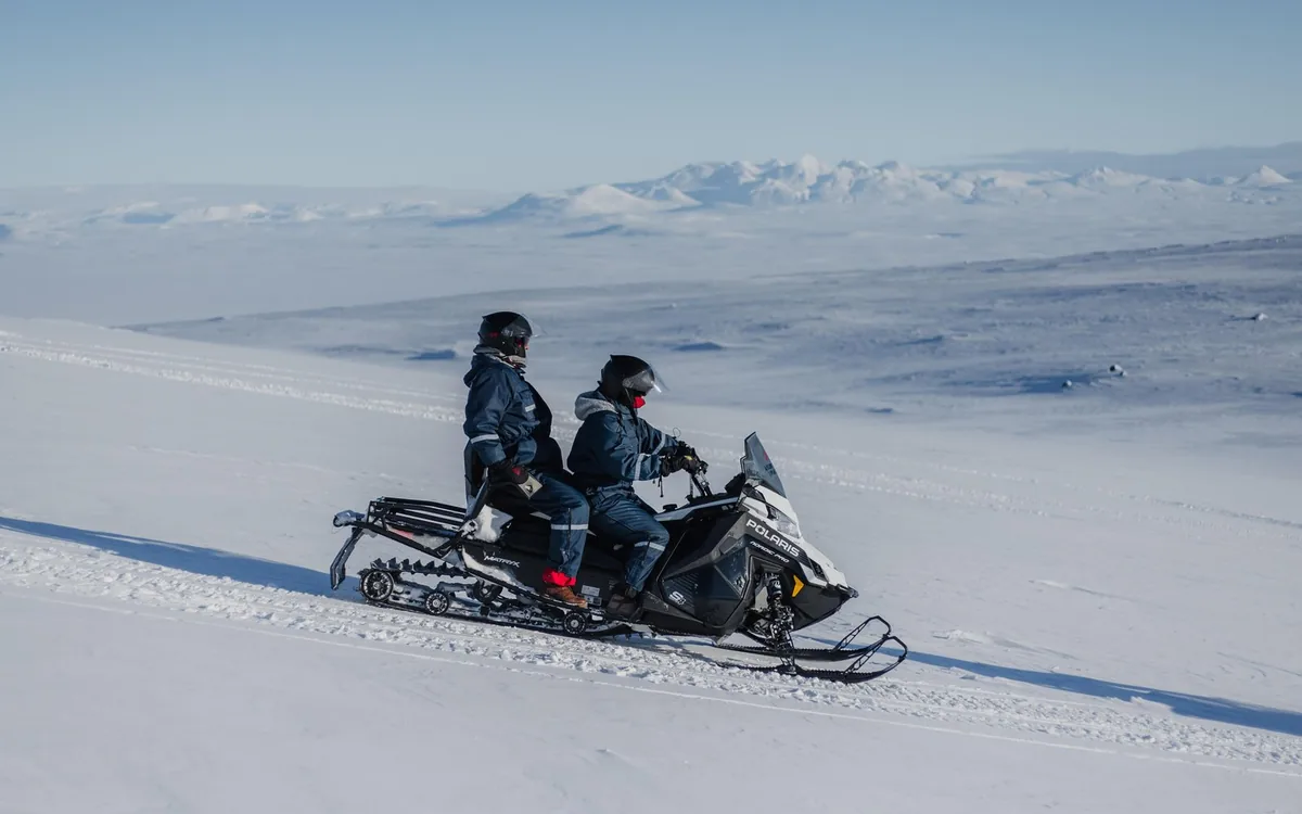 Two riders on a snowmobile crossing the Langjökull ice cap